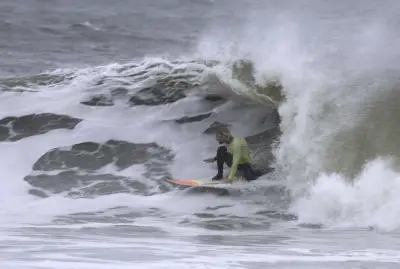 Thrill-seeking surfers flock to NYC for gnarly 10-foot nor’easter waves: ‘Floating between mountains’