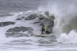 Thrill-seeking surfers flock to NYC for gnarly 10-foot nor’easter waves: ‘Floating between mountains’